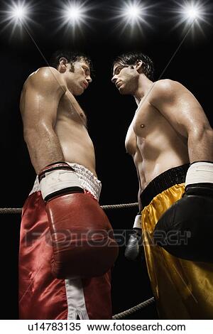 Stock Photography - Boxers facing off in boxing ring. Fotosearch