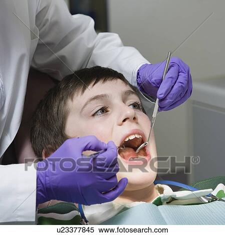 Boy being examined by dentist View Large Photo Image Stock Photography - Boy being examined by dentist. Fotosearch