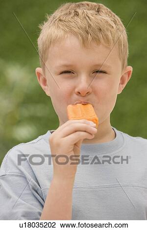 Stock Image - Boy eating ice pop. Fotosearch