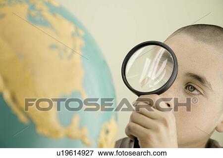 Boy examining globe with magnifying glass View Large Photo Image Stock Photo - Boy examining globe with magnifying glass. Fotosearch