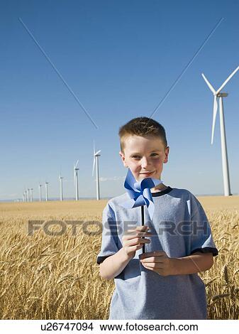 Picture - Boy holding pinwheel on wind farm. Fotosearch