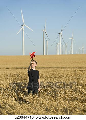 Boy holding pinwheel on wind farm View Large Photo Image Stock Photograph - Boy holding pinwheel on wind farm. Fotosearch