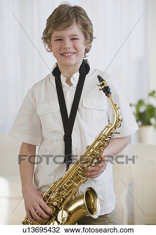 Stock Image - Boy holding saxophone. Fotosearch