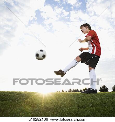 Boy in uniform kicking soccer ball View Large Photo Image Stock Photograph - Boy in uniform kicking soccer ball. Fotosearch
