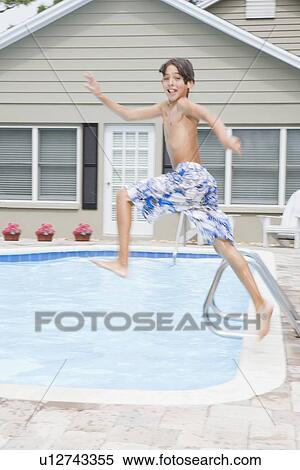 Stock Photography - Boy jumping into swimming pool. Fotosearch