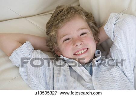 Boy laying on sofa View Large Photo Image Stock Photo - Boy laying on sofa. Fotosearch