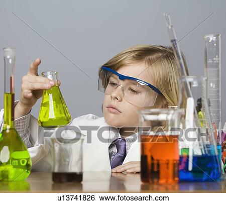 Stock Photograph - Boy looking at beaker of liquid. Fotosearch