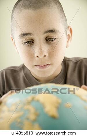 Stock Image - Boy looking at globe. Fotosearch