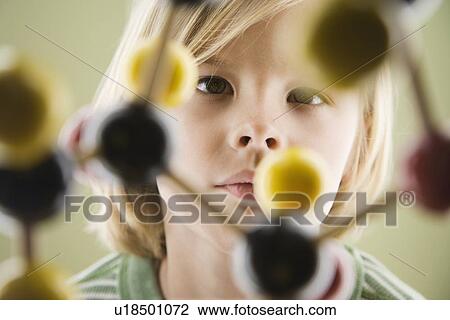 Stock Image - Boy looking at molecular model. Fotosearch
