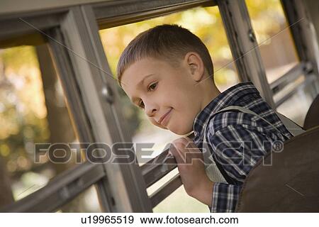 Boy looking out school bus window View Large Photo Image Stock Photo - Boy looking out school bus window. Fotosearch