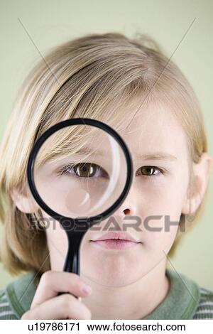 Stock Image - Boy looking though magnifying glass. Fotosearch