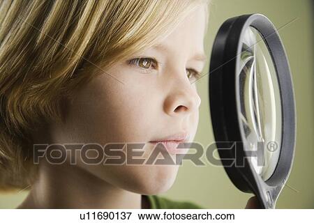 Stock Photo - Boy looking through magnifying glass. Fotosearch