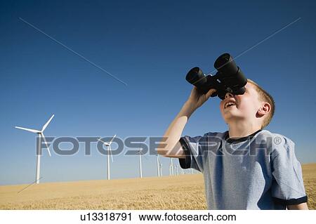 Boy on wind farm looking through binoculars View Large Photo Image Stock Image - Boy on wind farm looking through binoculars. Fotosearch