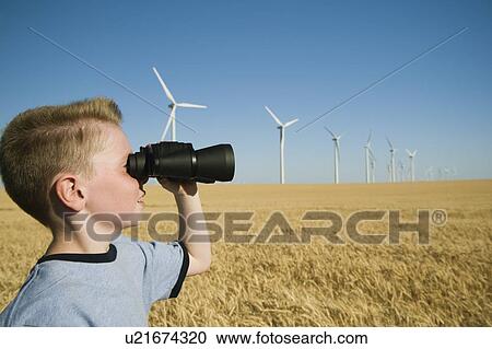 Boy on wind farm looking through binoculars View Large Photo Image Stock Image - Boy on wind farm looking through binoculars. Fotosearch
