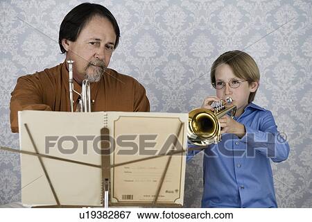 Stock Photo - Boy playing trumpet for teacher. Fotosearch
