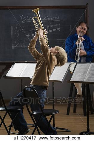 Boy playing trumpet in classroom View Large Photo Image Stock Photo - Boy playing trumpet in classroom. Fotosearch