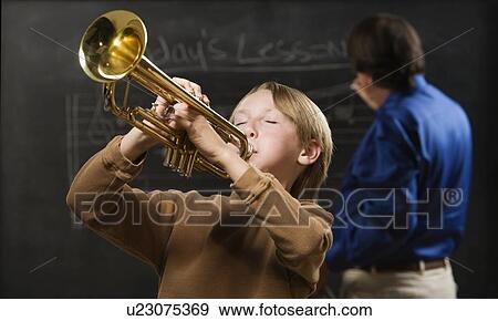 Boy playing trumpet in classroom View Large Photo Image Stock Photo - Boy playing trumpet in classroom. Fotosearch
