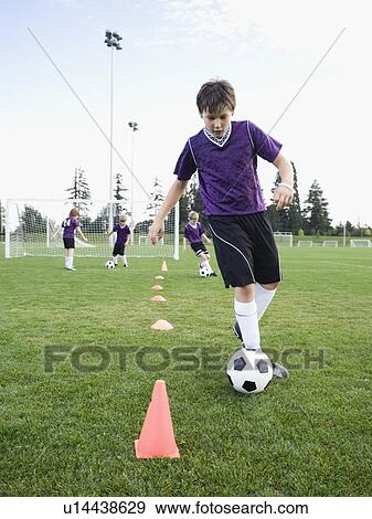 Stock Photo - Boy practicing soccer drills. Fotosearch