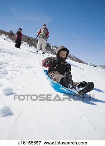 Boy riding on sled View Large Photo Image Stock Photo - Boy riding on sled. Fotosearch