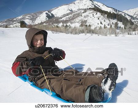 Boy riding on sled View Large Photo Image Stock Photograph - Boy riding on sled. Fotosearch