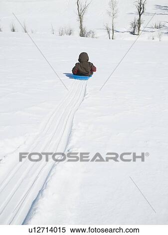 Stock Photography - Boy riding on sled. Fotosearch