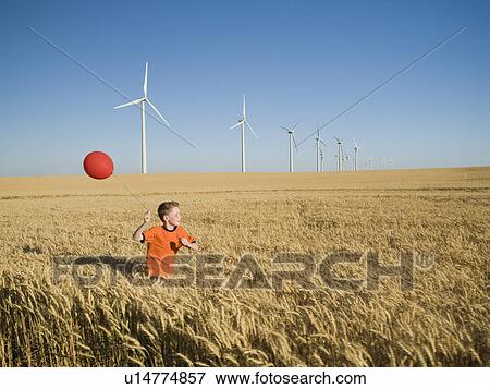 Boy running with balloon on wind farm View Large Photo Image Stock Photo - Boy running with balloon on wind farm. Fotosearch