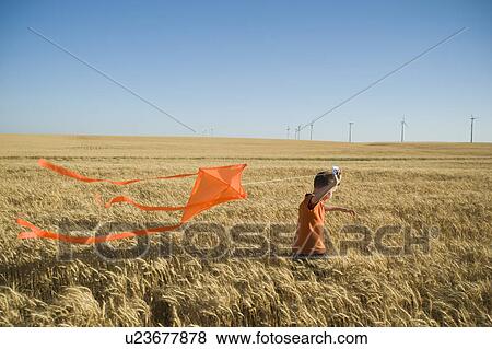 Boy running with kite on wind farm View Large Photo Image Stock Photo - Boy running with kite on wind farm. Fotosearch