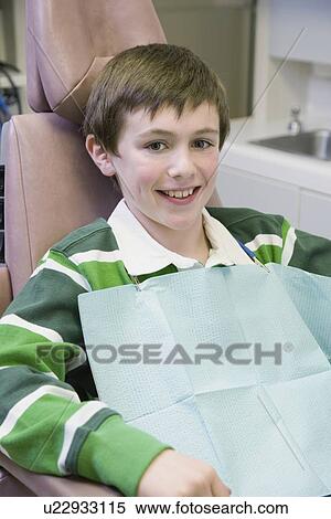 Stock Photography - Boy sitting in dentist’s chair. Fotosearch