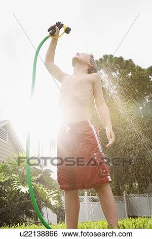 Boy spraying himself with garden hose View Large Photo Image Stock Photograph - Boy spraying himself with garden hose. Fotosearch