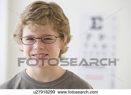 Boy wearing eyeglasses in front of eye chart View Large Photo Image Stock Photo - Boy wearing eyeglasses in front of eye chart. Fotosearch