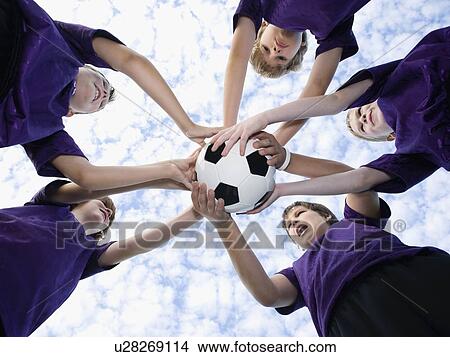 Picture - Boys holding soccer ball in huddle. Fotosearch