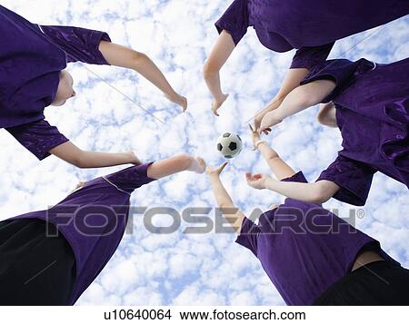 Picture - Boys in huddle throwing soccer ball in air. Fotosearch