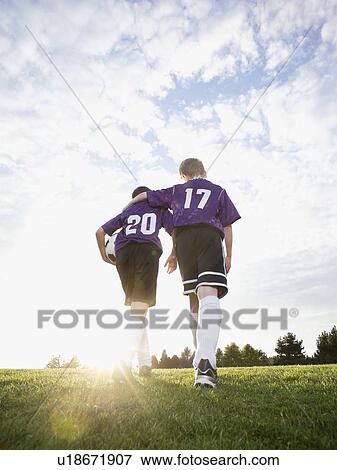 Boys in soccer uniforms walking on field View Large Photo Image Stock Photo - Boys in soccer uniforms walking on field. Fotosearch