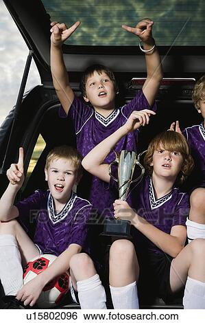 Boys soccer team holding trophy in back of car View Large Photo Image Stock Photograph - Boys soccer team holding trophy in back of car. Fotosearch