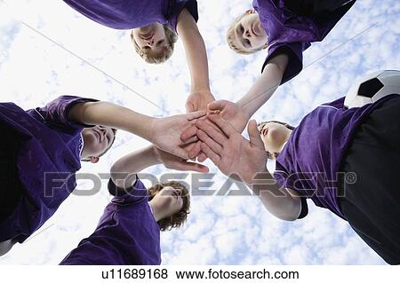Boys touching hands in huddle View Large Photo Image Stock Photo - Boys touching hands in huddle. Fotosearch