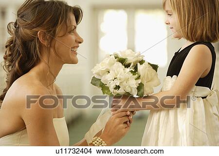 Picture - Bride handing bouquet to flower girl. Fotosearch