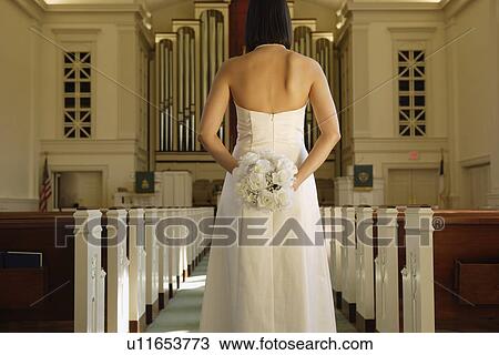 Stock Image - Bride holding bouquet behind back. Fotosearch