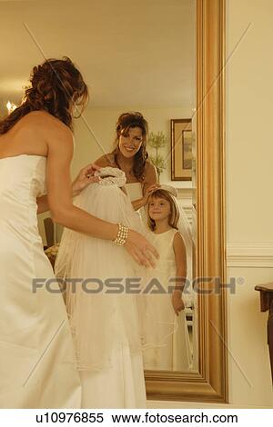 Stock Photography - Bride putting veil on flower girl. Fotosearch