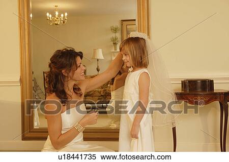 Stock Photography - Bride putting veil on flower girl. Fotosearch