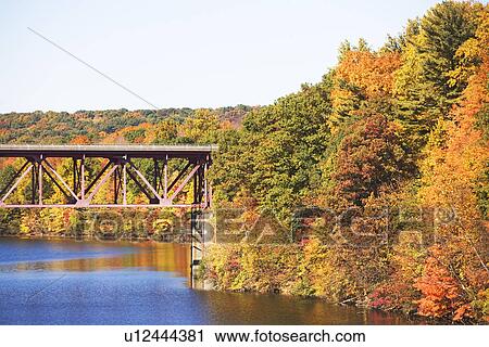 Stock Image - Bridge among autumn foliage, New York. Fotosearch