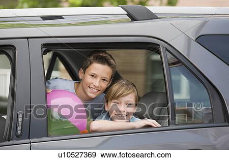 Brother and sister looking out car window View Large Photo Image Stock Photo - Brother and sister looking out car window. Fotosearch