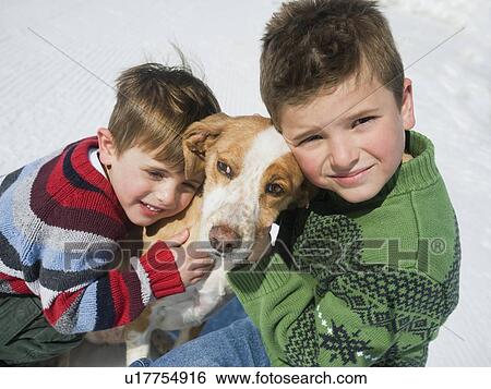Stock Photograph - Brothers hugging dog. Fotosearch
