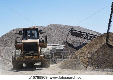 Stock Photo - Bucket loader moving pile of gravel. Fotosearch
