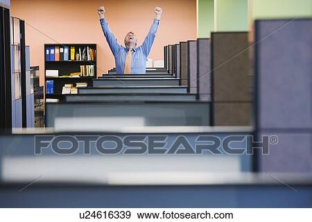Stock Photo - Businessman cheering in cubicle. Fotosearch
