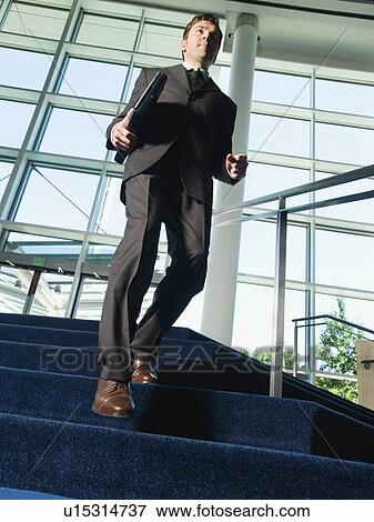 Businessman descending office building stairs View Large Photo Image Stock Photo - Businessman descending office building stairs. Fotosearch