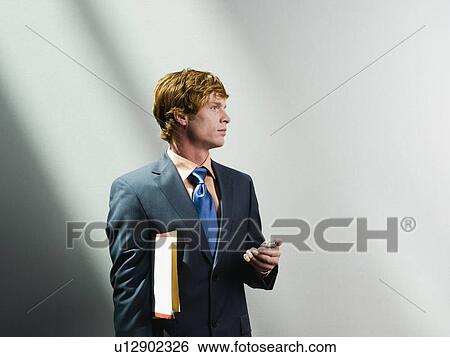 Businessman holding cell phone and files View Large Photo Image Stock Photograph - Businessman holding cell phone and files. Fotosearch