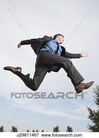 Businessman jumping in mid-air View Large Photo Image Stock Photo - Businessman jumping in mid-air. Fotosearch