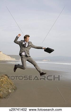 Businessman jumping on beach View Large Photo Image Stock Image - Businessman jumping on beach. Fotosearch