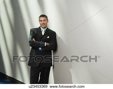 Stock Photo - Businessman leaning against wall. Fotosearch