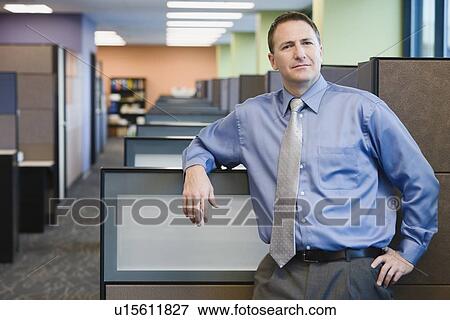 Stock Photo - Businessman leaning on cubicle wall. Fotosearch